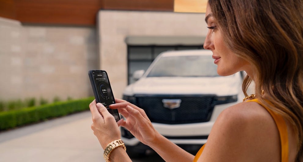 lady checking her mobile with a Cadillac vehicle background | Classic Cadillac of Galveston in GALVESTON TX